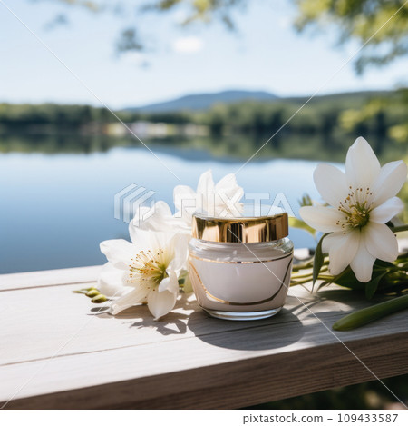 cream in a jar on table by lake with flowers, 109433587