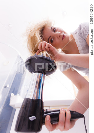 Woman doing curls with hairdryer diffuser 109434230