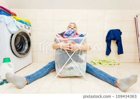Woman with big basket of dirty clothes laundry. 109434363