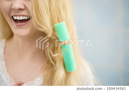 Blonde woman using hair rollers 109434561