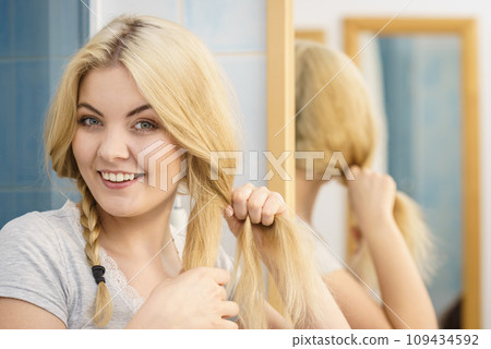 Woman making braid on blonde hair 109434592