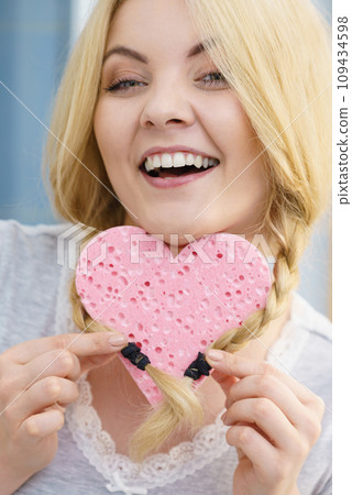 Blonde woman in braids holding heart 109434598