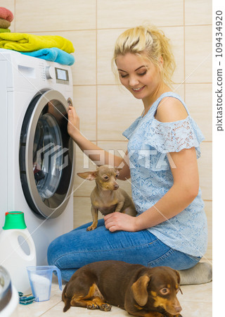 Woman setting washing machine Woman setting washing machine 109434920