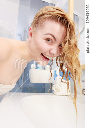 Woman having wet blonde hair 109434961
