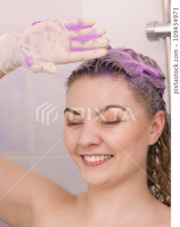 Woman applying toner shampoo on her hair Woman applying toner shampoo on her hair 109434973