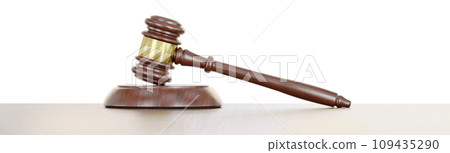 Gavel Resting on a Wooden Table Against a White Background. 109435290