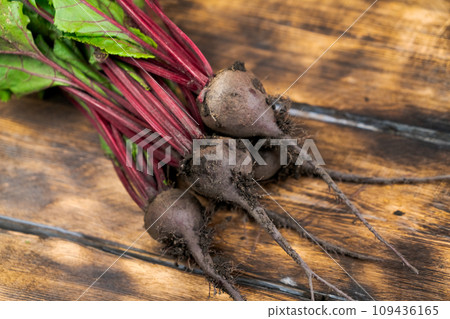 dirty in the ground fresh beets lie on a wooden table 109436165