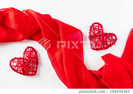 Red hearts and silk ribbon on a white background 109436365