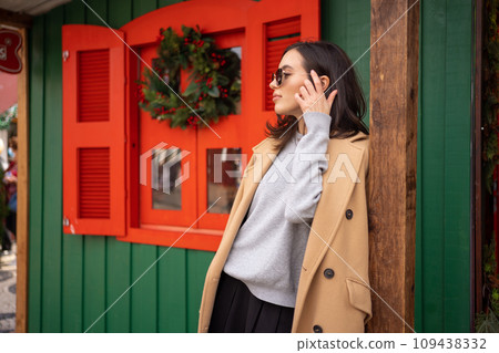 Woman standing sideways near Christmas store 109438332