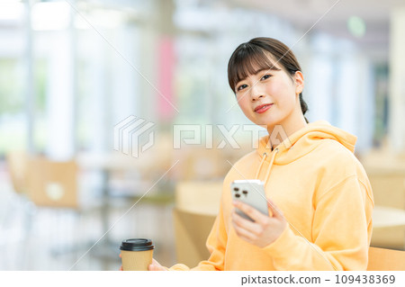 Female college student using a smartphone in the lounge Photography cooperation: Ariake College of Education and Arts Female college student using a smartphone in the lounge Photography cooperation: Ariake College of Education and Arts 109438369