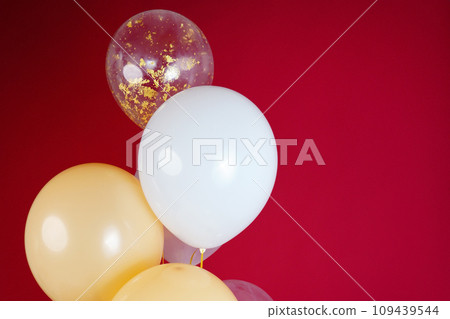 Light balloons - white, beige, transparent, pearl on a red background. Horizontal photo. Space for text 109439544