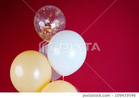 Light balloons - white, beige, transparent, pearl on a red background. Horizontal photo. Space for text Light balloons - white, beige, transparent, pearl on a red background. Horizontal photo. Space for text 109439546