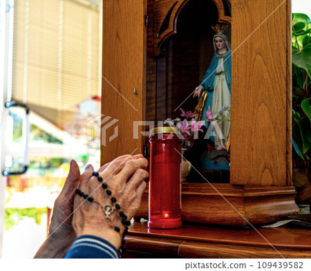 hands of a woman raised to an image of a saint hands of a woman raised to an image of a saint 109439582
