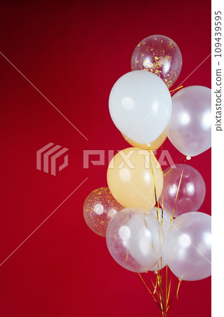 A bunch of light balloons on a red background. Vertical Photo Space for Text 109439595