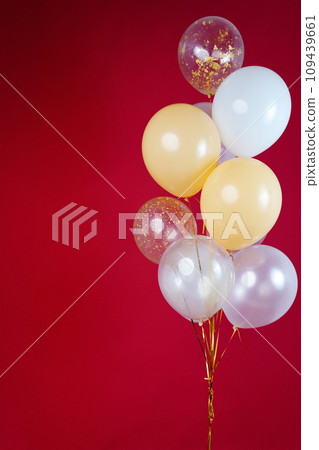 A bunch of light balloons on a red background. Vertical Photo Space for Text 109439661