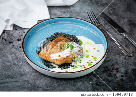 black beans with big fish steak, green onions and cream sauce, top view 109439718
