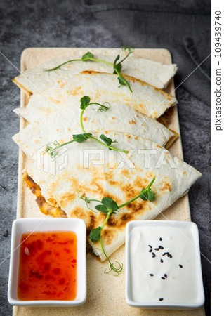 crispy flatbreads stuffed with meat, herbs, lime and two sauces, side view 109439740