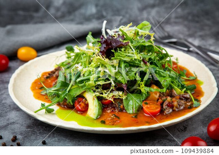 warm Asian salad with horse meat and herbs side view 109439884