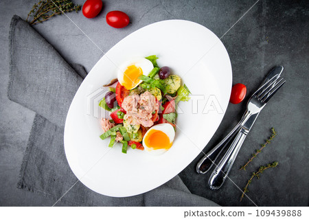 salad with soft-boiled egg, tuna, green onions, boiled potatoes, top view salad with soft-boiled egg, tuna, green onions, boiled potatoes, top view 109439888