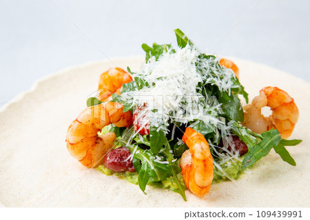 beautifully served shrimp with arugula and grated cheese, side view 109439991