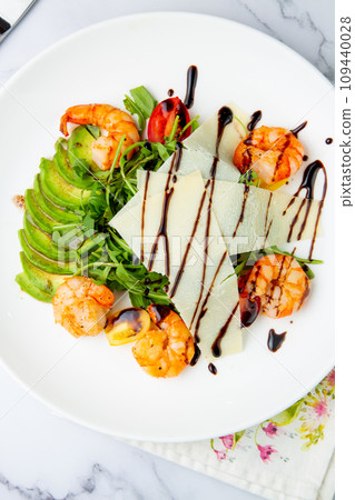 shrimp with avocado slices and arugula with teriyaki sauce side view 109440028