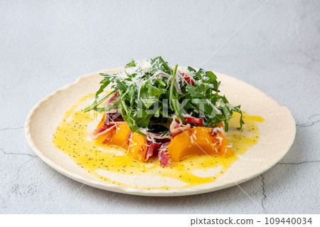 green salad with arugula and lingonberries on a white plate and marble background top view 109440034
