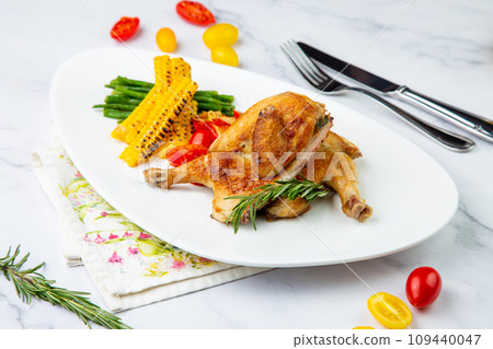 chicken thighs with corn, cherry tomatoes and herbs side view 109440047