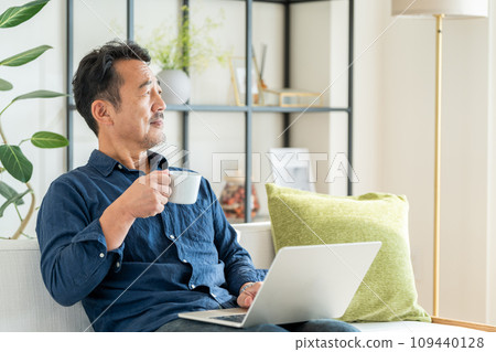 A senior man relaxing in the living room. A senior man relaxing in the living room. 109440128