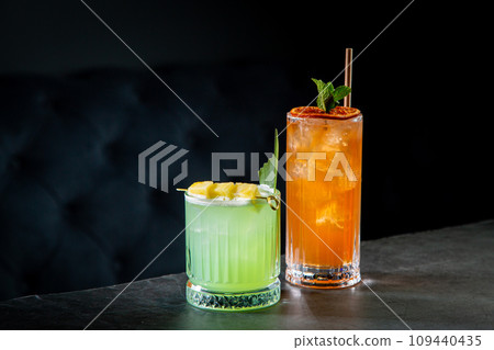 tropical cocktail with sunset gradient and citrus side view 109440435