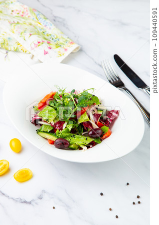 salad of greens, lettuce leaves, cucumbers, pink onions, side view salad of greens, lettuce leaves, cucumbers, pink onions, side view 109440591