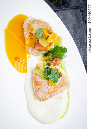 breaded fish fillet with pineapple, parsley and cream sauce, top view 109440795