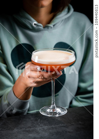 iced latte with foam in a martini glass on a dark background 109440813