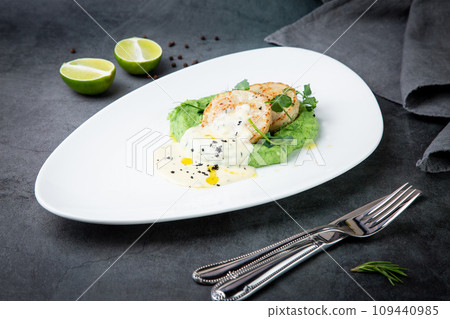 cheesecakes with creamy sauce on broccoli puree, side view 109440985