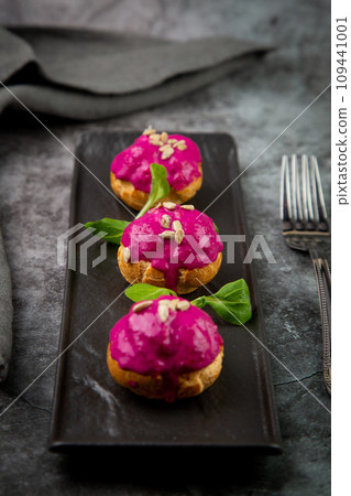dessert of baked buns with raspberry topping and seed decorations, side view dessert of baked buns with raspberry topping and seed decorations, side view 109441001