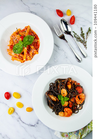 black noodles with mussels, shrimp, tomatoes and herbs side view 109441180