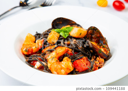 black noodles with mussels, shrimp, tomatoes and herbs side view black noodles with mussels, shrimp, tomatoes and herbs side view 109441188