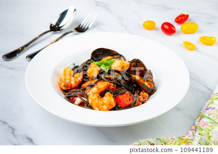 black noodles with mussels, shrimp, tomatoes and herbs side view 109441189
