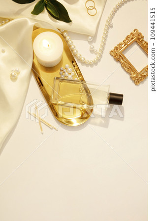 Flat lay, top view trendy lifestyle blog with decorative pearl jewelry on white background with candles and silk fabric. Mockup for unlabeled perfume bottle displayed for advertising. Copy space Flat lay, top view trendy lifestyle blog with decorative pearl jewelry on white background with candles and silk fabric. Mockup for unlabeled perfume bottle displayed for advertising. Copy space 109441515