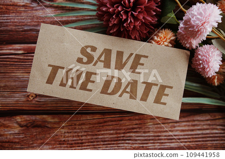 Save the Date text message with flower decoration on wooden background Save the Date text message with flower decoration on wooden background 109441958