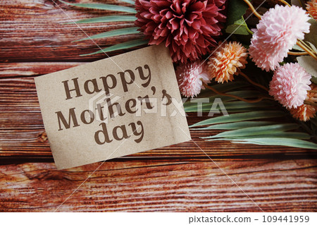 Happy Mothers day text message with flower decoration on wooden background 109441959