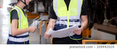 Young caucasian engineer man and woman or worker look blueprint and checking electric train. 109442028