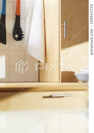 A sunny kitchen with white tile walls, a wooden table and sink. 109443729