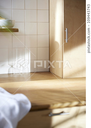 A sunny kitchen with white tile walls, a wooden table and sink. A sunny kitchen with white tile walls, a wooden table and sink. 109443743