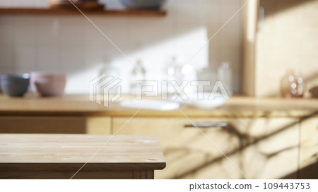 A sunny kitchen with white tile walls, a wooden table and sink. 109443753