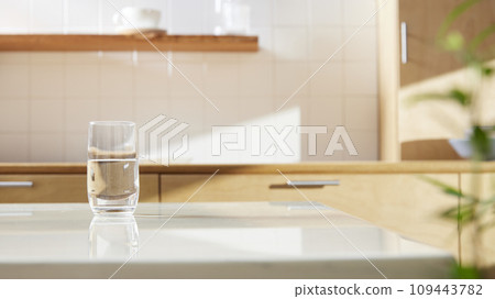 A sunny kitchen with white tile walls, a wooden table and sink. A sunny kitchen with white tile walls, a wooden table and sink. 109443782