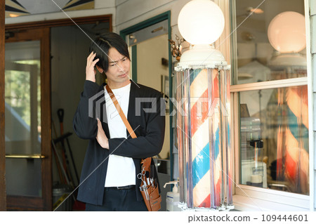 亞洲男性理髮師在理髮店前擔心 亞洲男性理髮師在理髮店前擔心 109444601