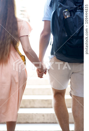 Tourism, travel. Young people couple holding hands walking through the city Tourism, travel. Young people couple holding hands walking through the city 109444835