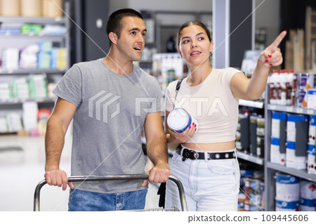 In hardware store, husband and wife are arguing about which paint is best to buy 109445606