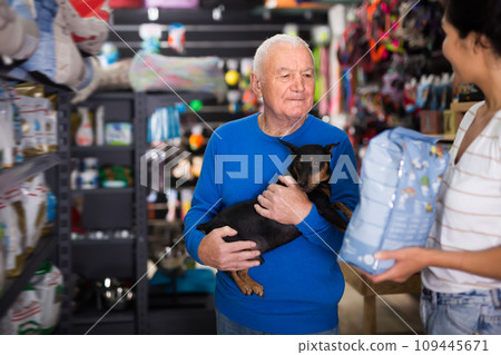 Woman helping an elderly man buy dog food 109445671