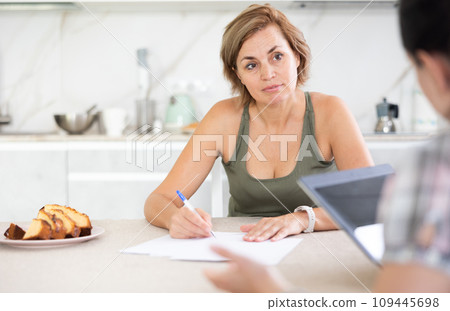 Woman listen attentively to woman of seller, who tells about advantages of making microloan in credit institution 109445698